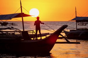 Fischer auf Boot bei Sonnenuntergang